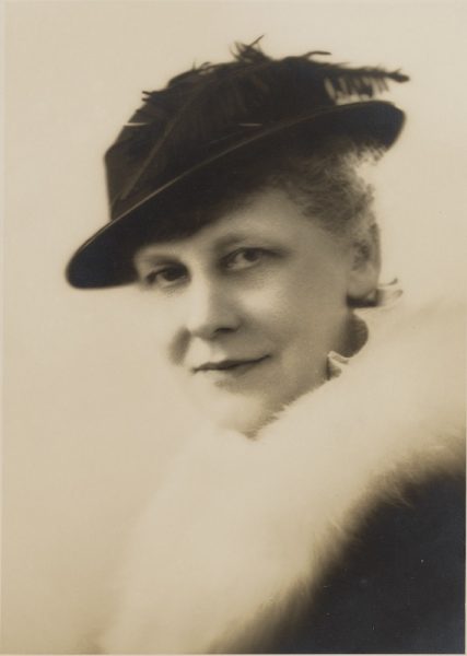 A headshot of Florence Mary Taylor. She is wearing a stylish hat with a feather.