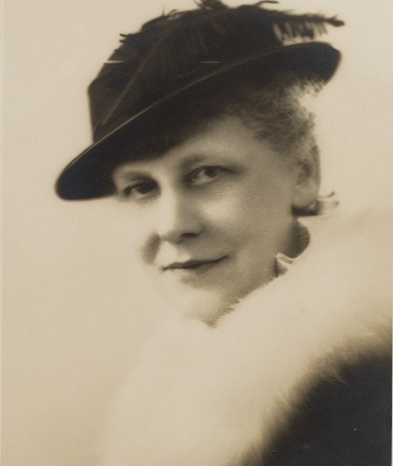 A headshot of Florence Mary Taylor. She is wearing a stylish hat with a feather.