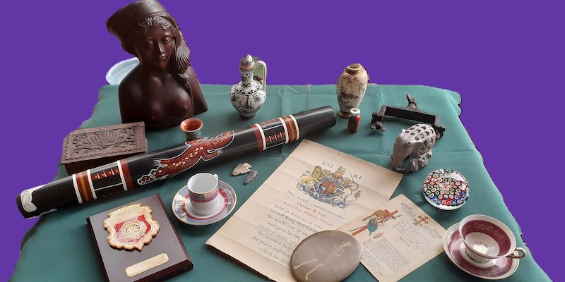 A collection of items, including ceramics, documents and figurines.